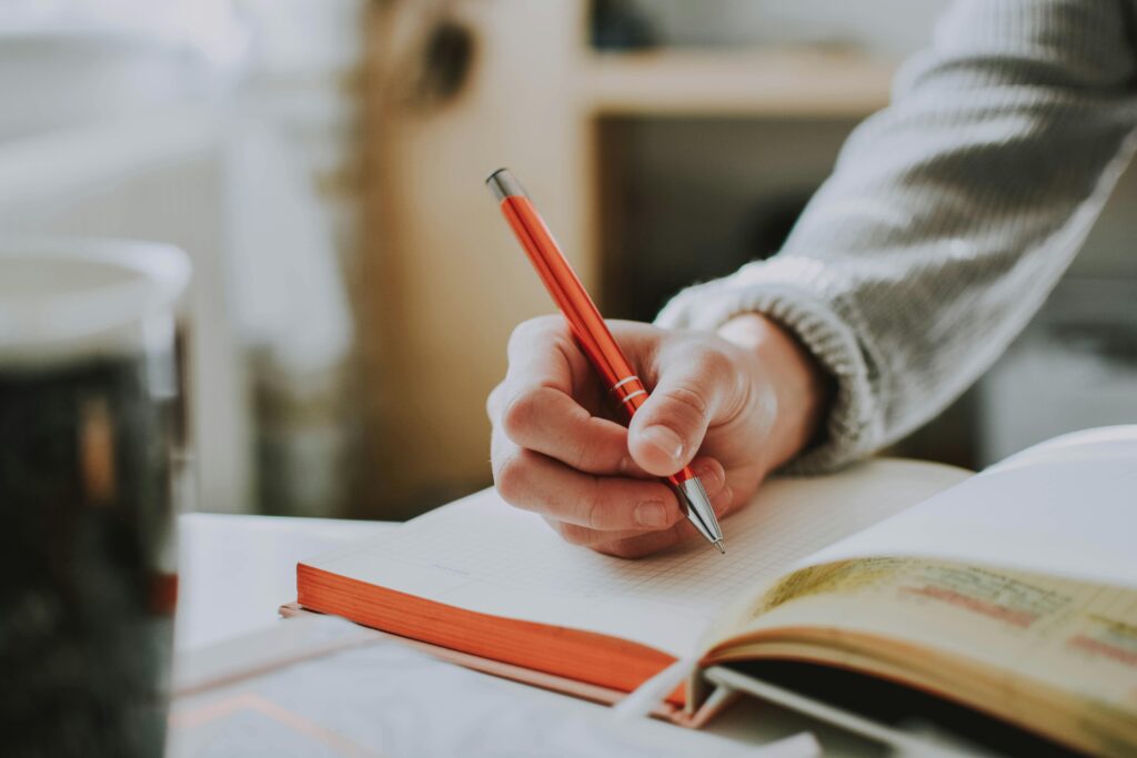 pexels-photo-1925536-1925536 • Life With A Purpose Person Holding Orange Pen